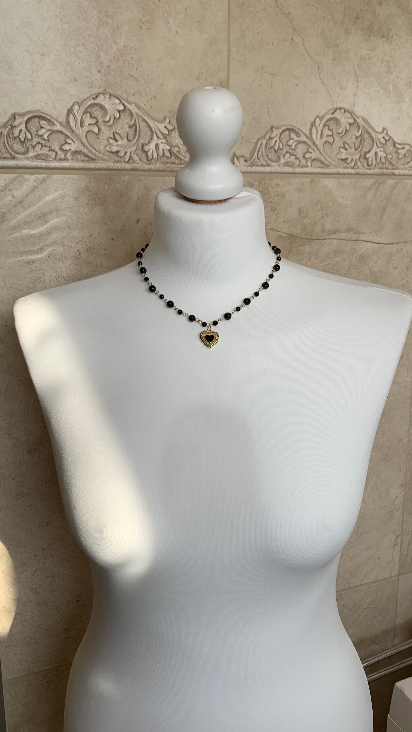 Elegant black onyx beaded necklace with a gold-plated heart pendant, handcrafted with sterling silver