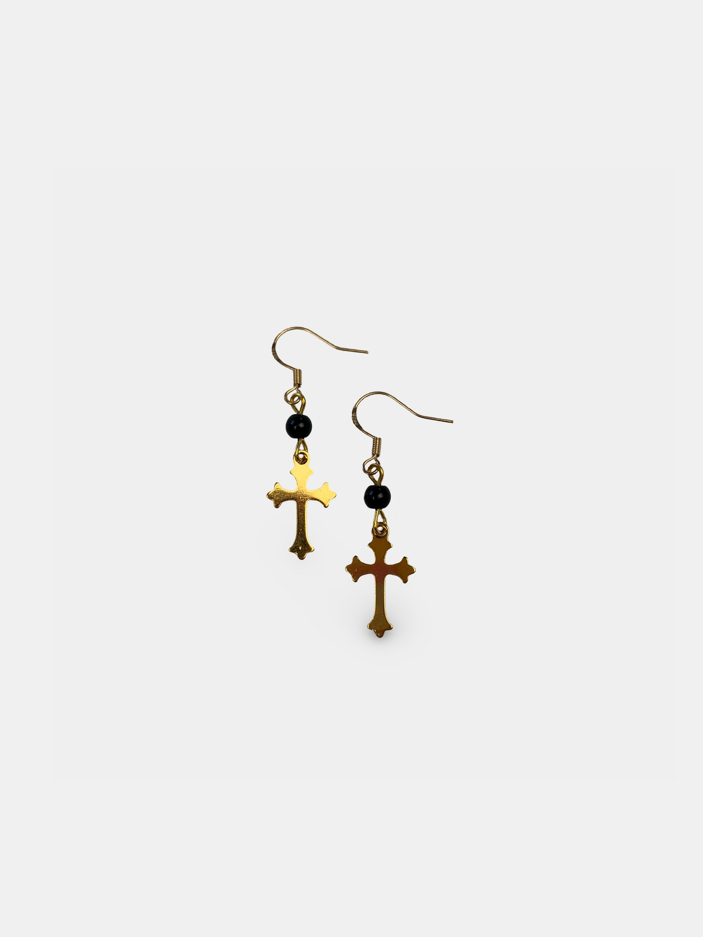 Gold cross dangle earrings with black onyx beads, gothic-inspired jewelry with vintage elegance.