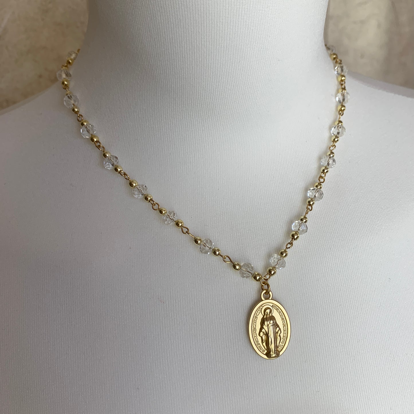 Ethereal religious necklace with sparkling clear crystals and a gold Virgin Mary pendant, evoking serenity and grace.
