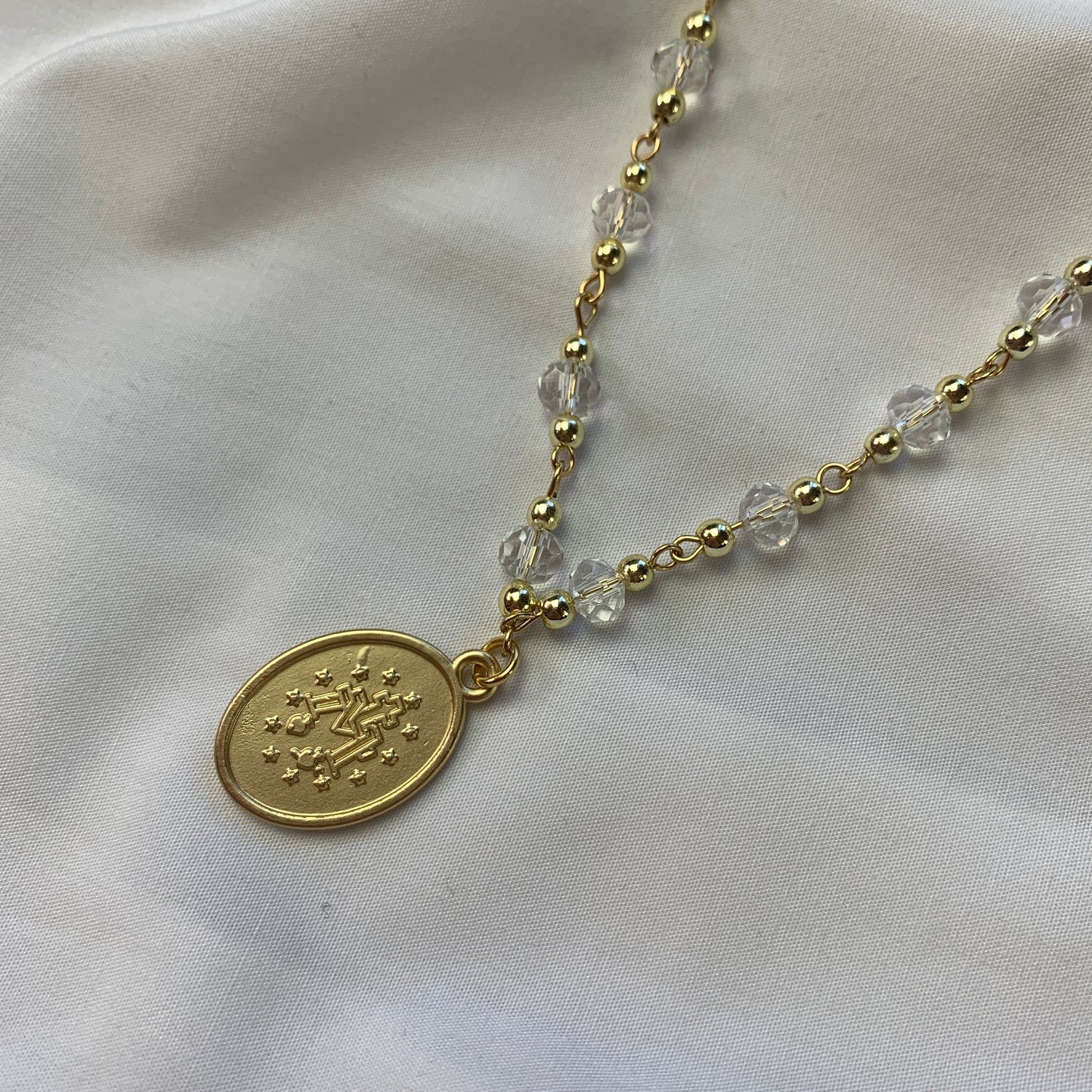 Gold and crystal Marian necklace, featuring the Virgin Mary medallion—a symbol of protection and devotion.
