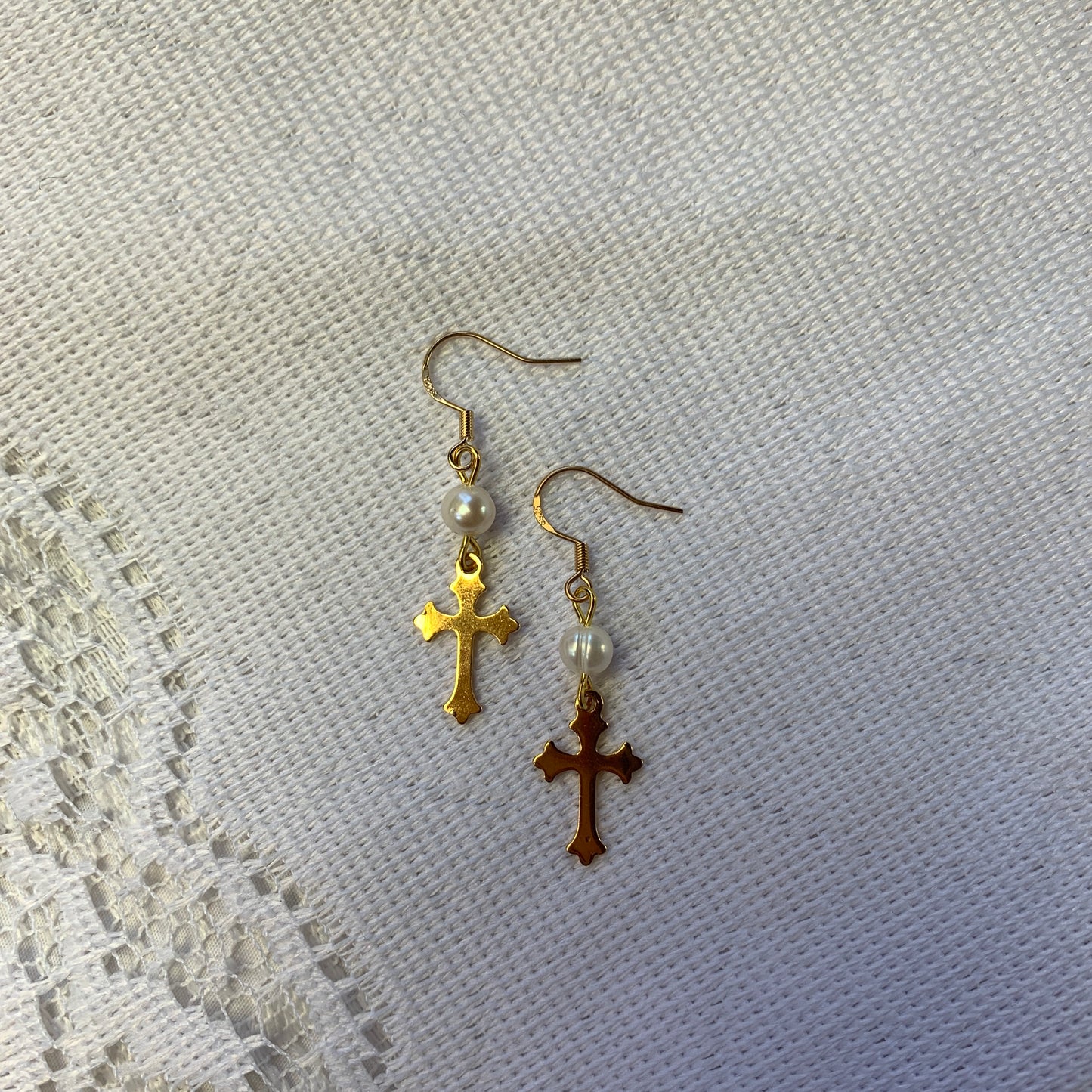 Punk jewelry, gold cross and pearl drop earrings, reminiscent of designer gothic and punk aesthetics.