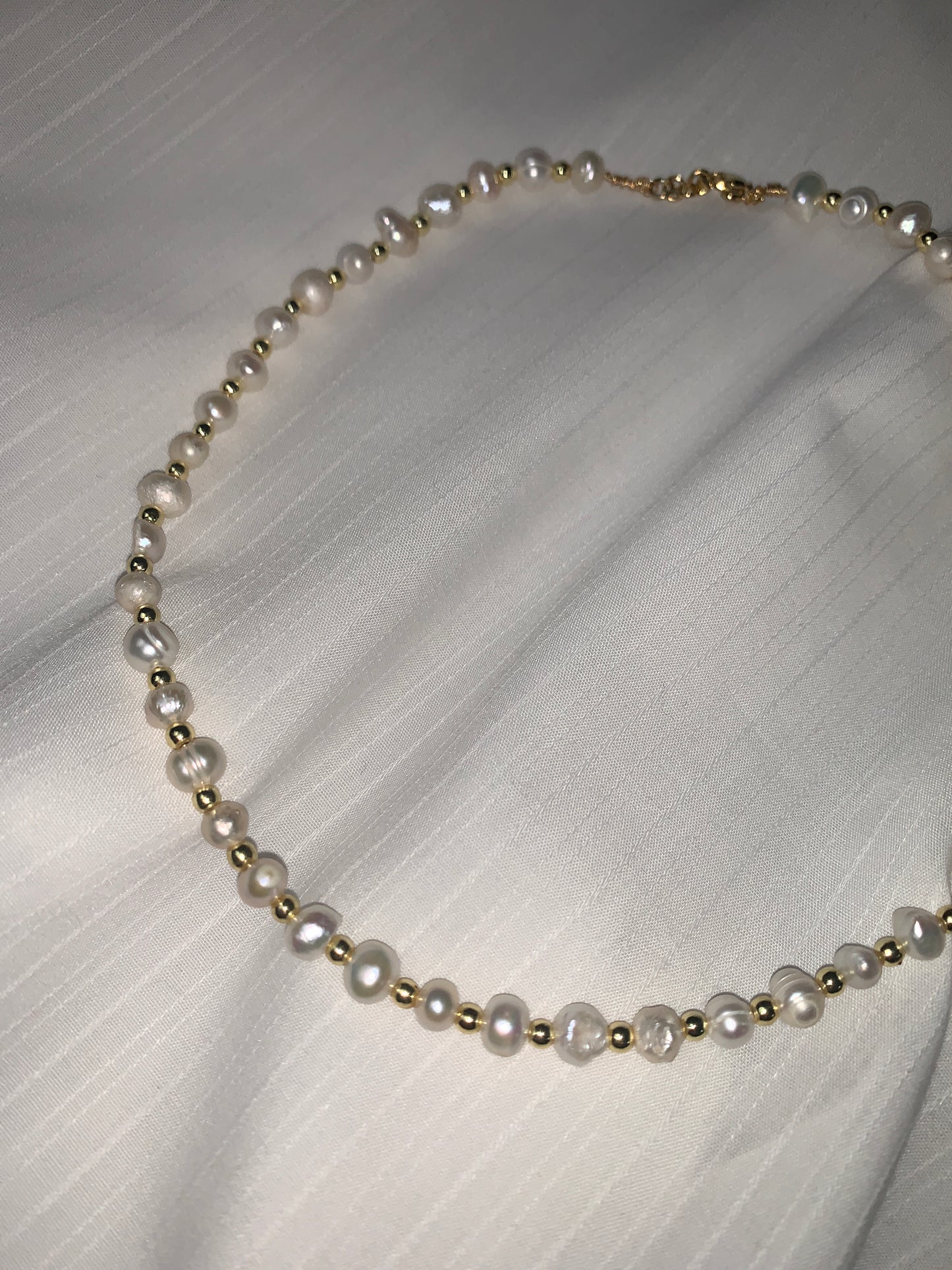 Handmade freshwater pearl necklace featuring irregular baroque pearls and a gold clasp, perfect for an elegant yet natural look.
