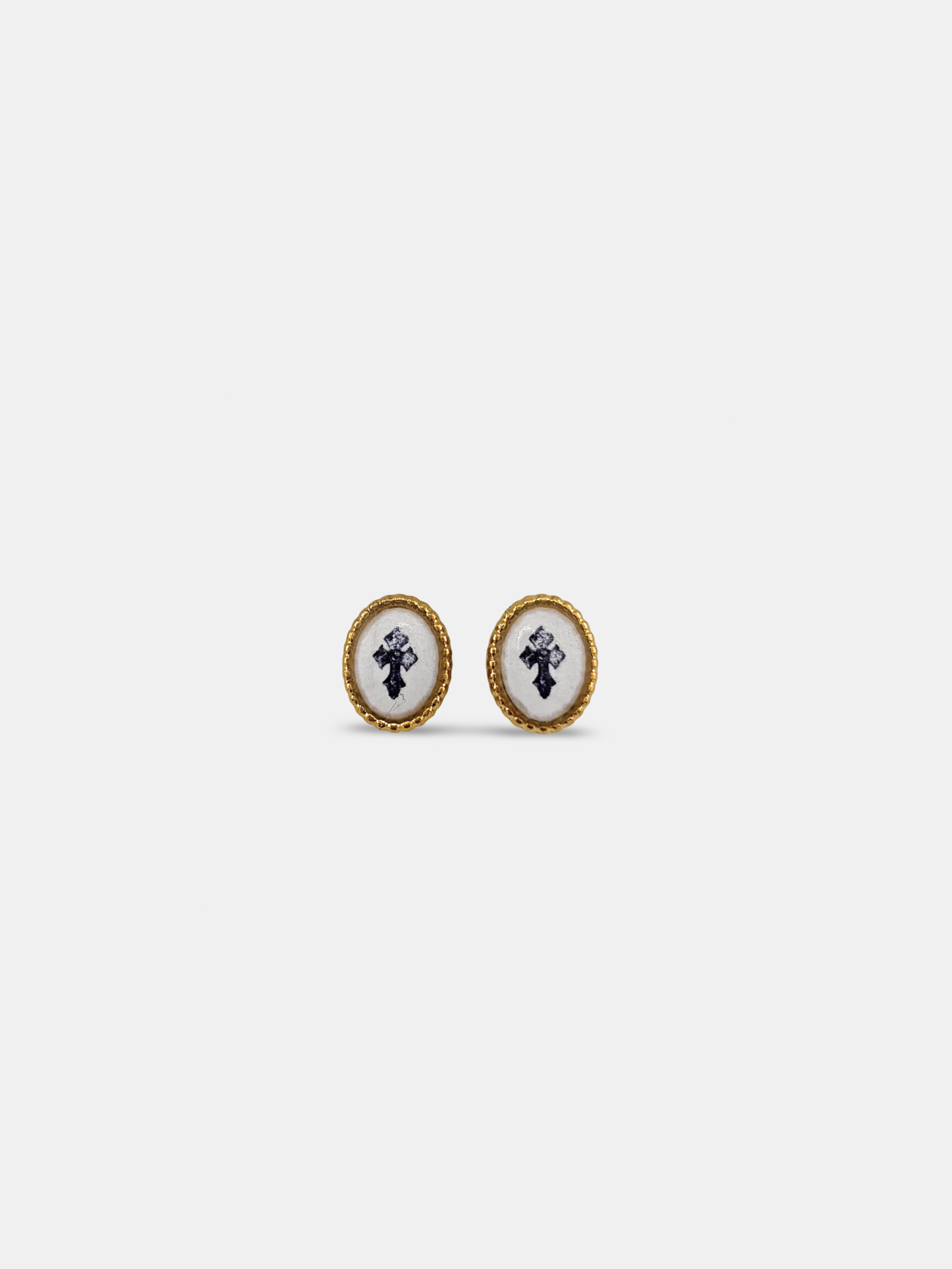 Vintage-inspired stud earrings with a painted cross cabochon in a gold setting.