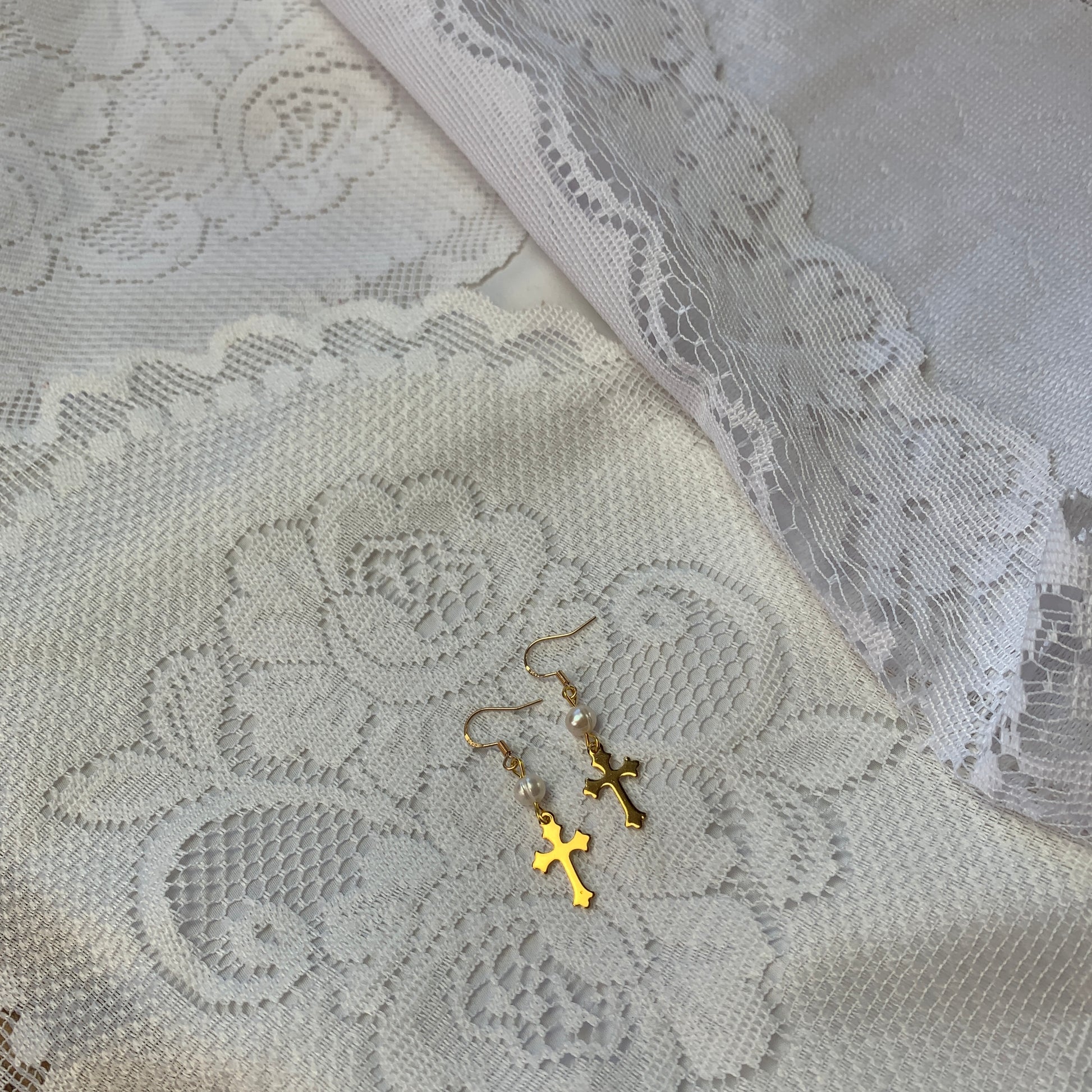 Classic gold cross earrings adorned with genuine pearls, blending antique elegance with modern sophistication.