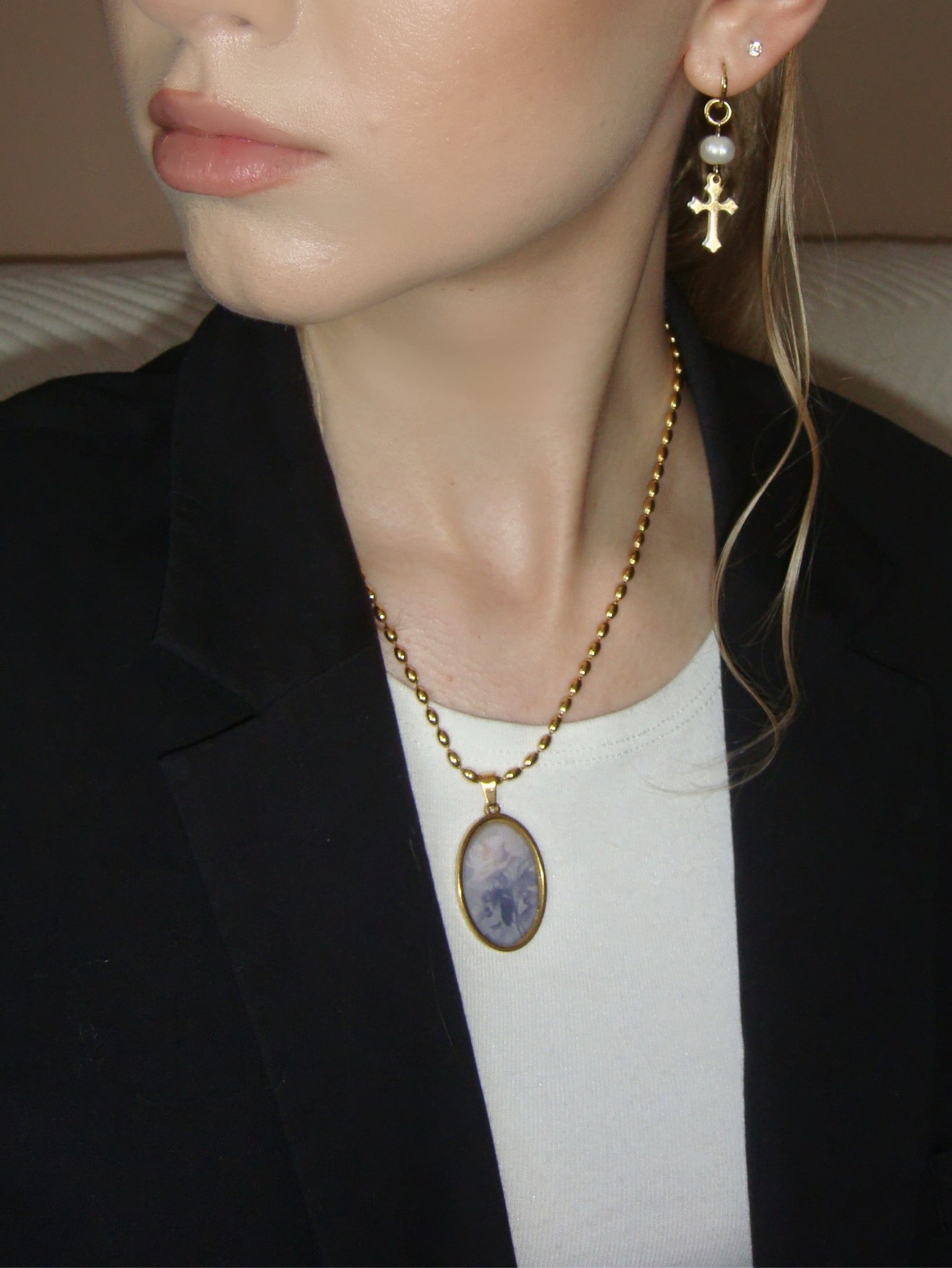 Delicate gold necklace showcasing a vintage-style oval pendant with a rose motif.