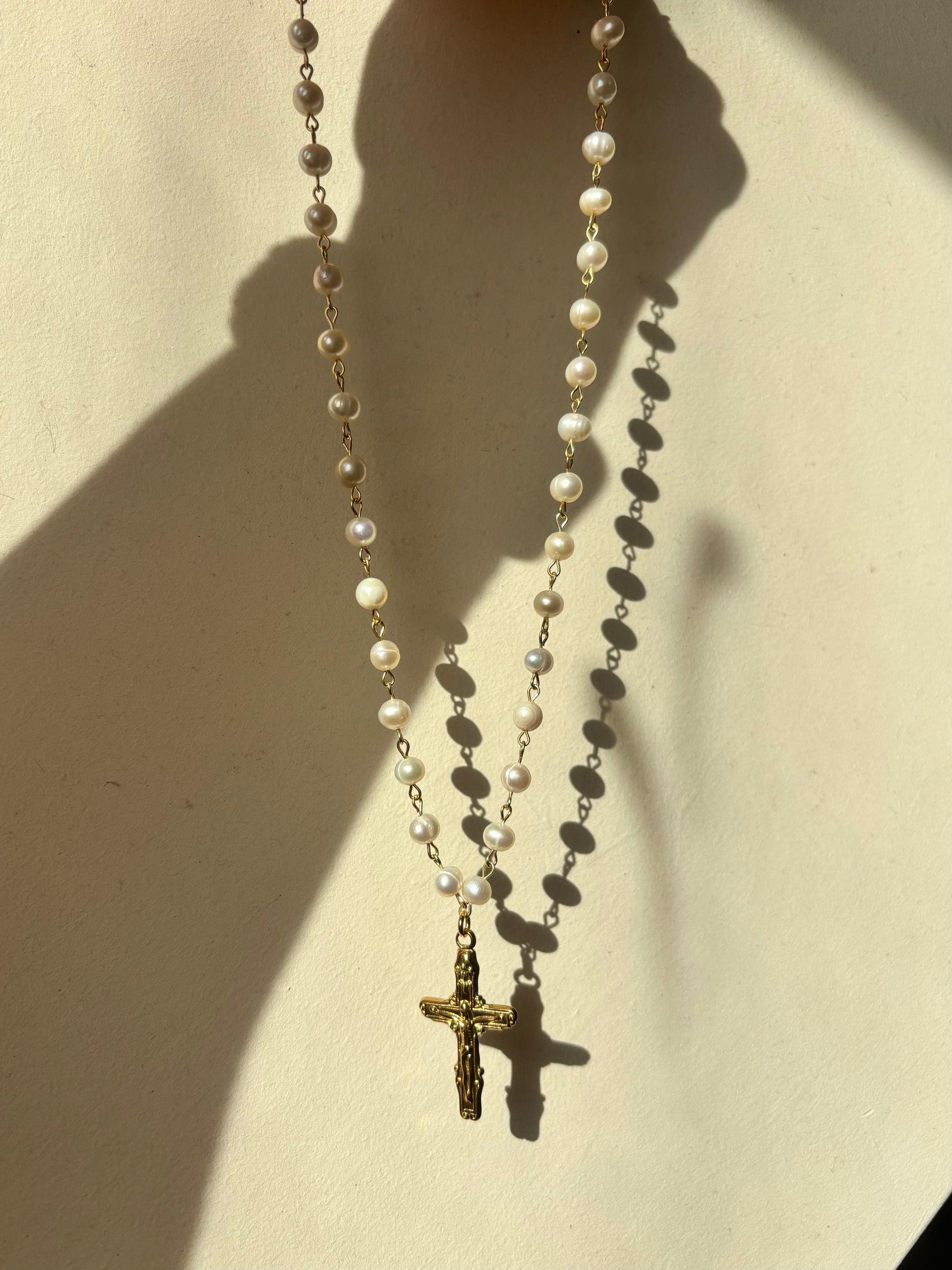 Handcrafted genuine pearl necklace featuring a detailed gold cross pendant, baroque and gothic style jewelry.