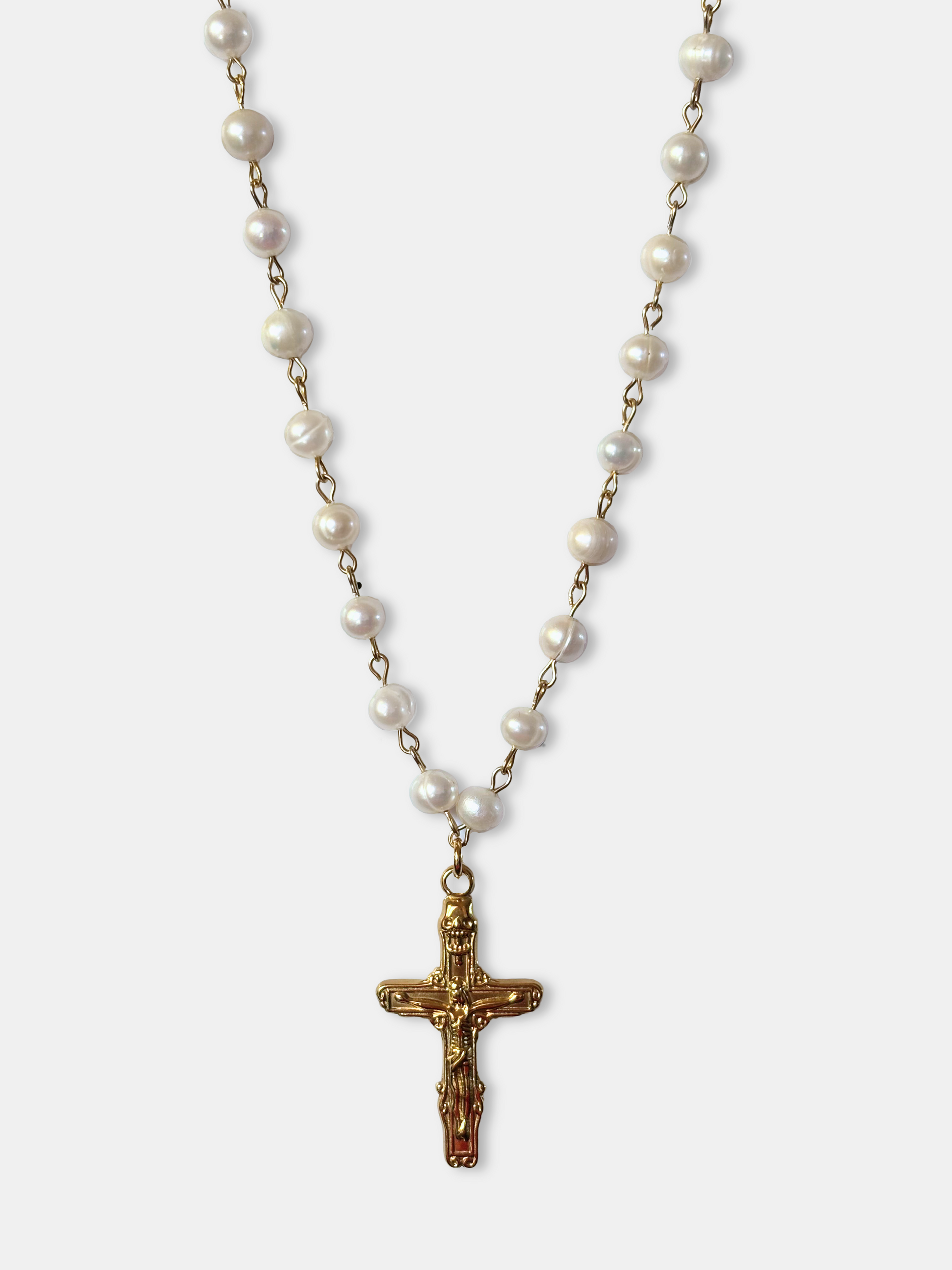 Close-up of a luxurious pearl bead necklace with a gold-plated cross pendant, ideal for gothic fashion lovers.