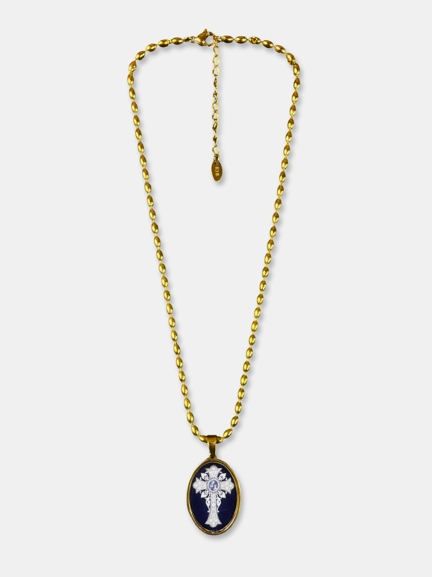 Oval cross pendant necklace with gold-filled chain and black enamel background.