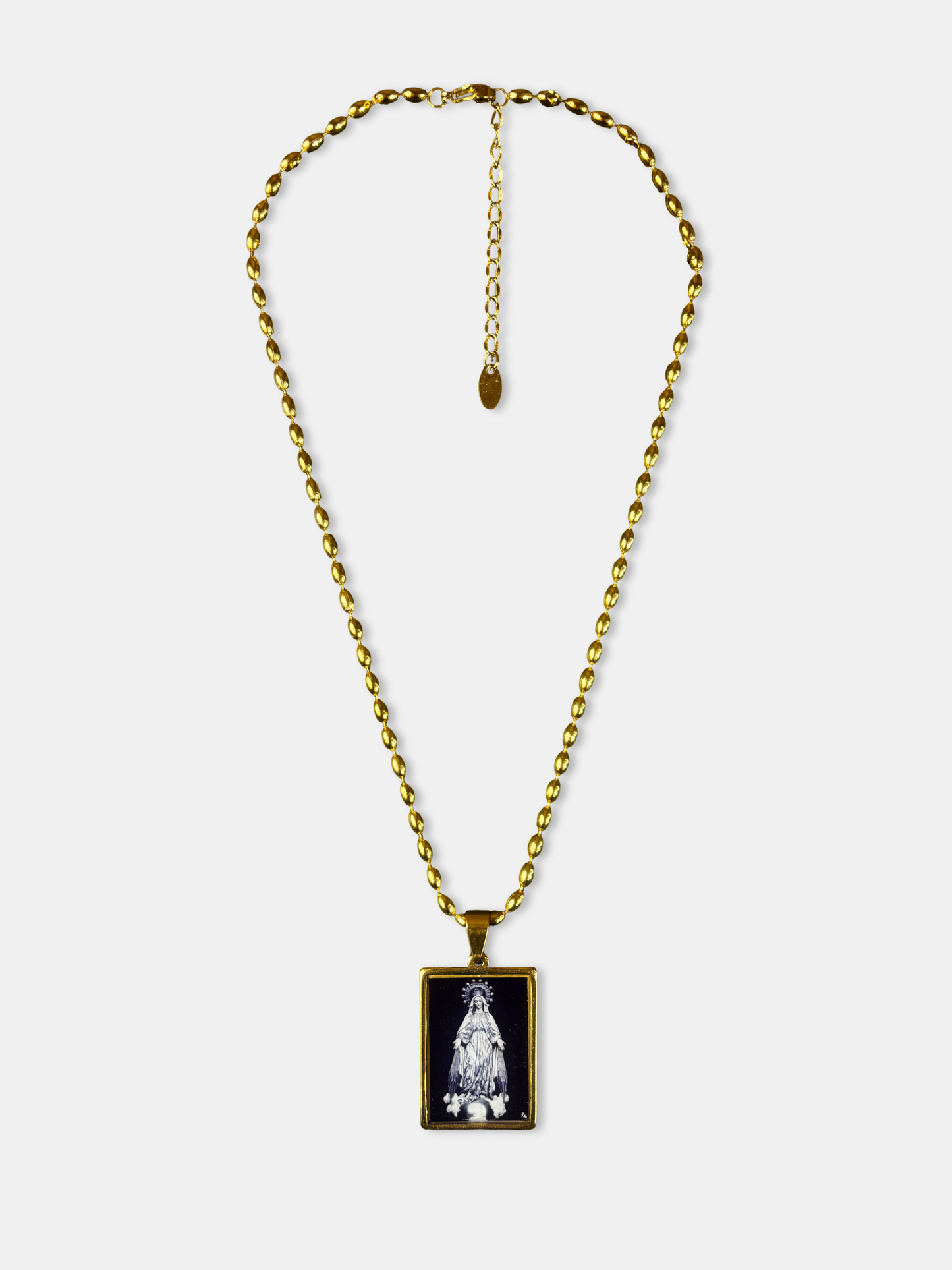Elegant gold-filled necklace with black enamel pendant depicting the Virgin Mary in white detail.