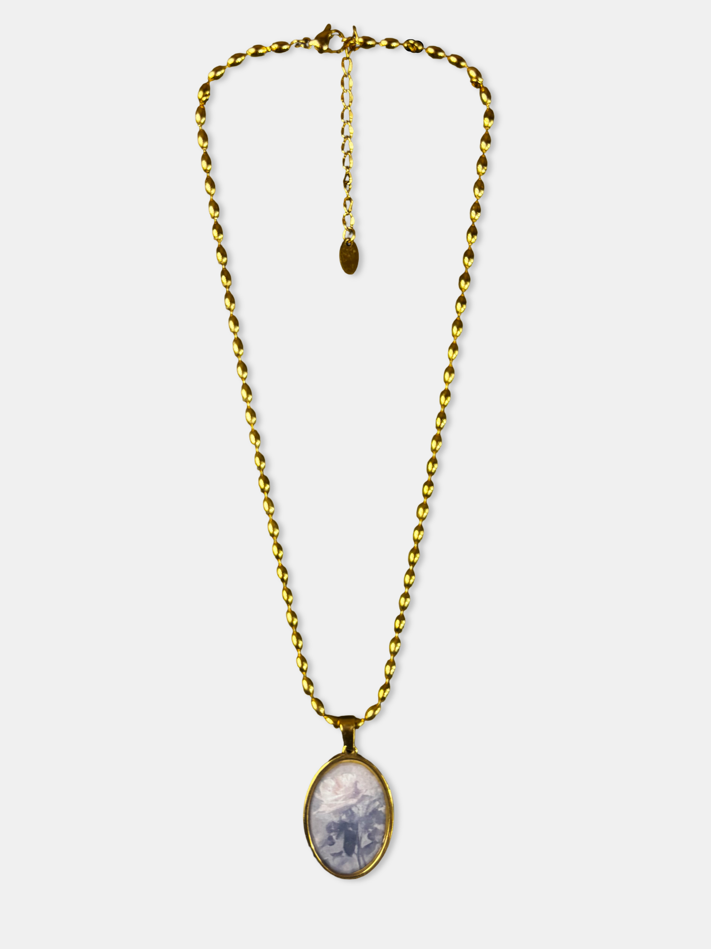 Gold necklace with oval pendant featuring a soft rose illustration, inspired by vintage romantic jewelry.