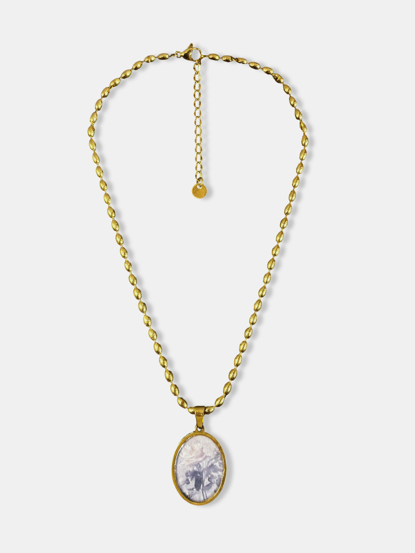 Gold necklace with oval pendant featuring a soft rose illustration, inspired by vintage romantic jewelry.