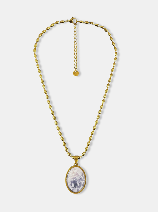 Gold necklace with oval pendant featuring a soft rose illustration, inspired by vintage romantic jewelry.