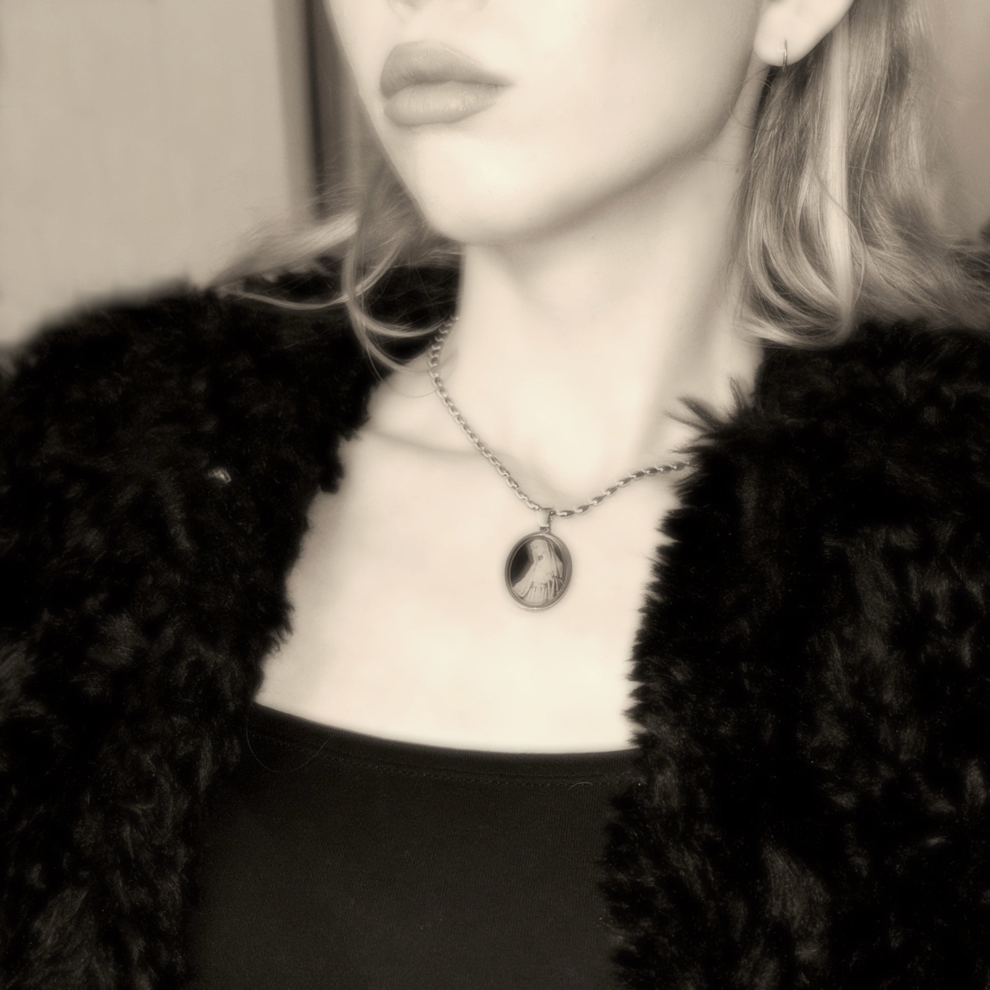 Elegant small oval pendant necklace in black and gold tones
