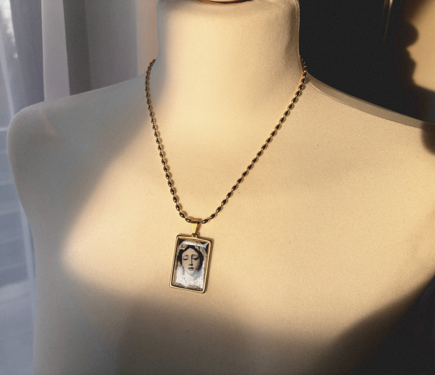 Artistic gold pendant necklace symbolizing sorrow and devotion