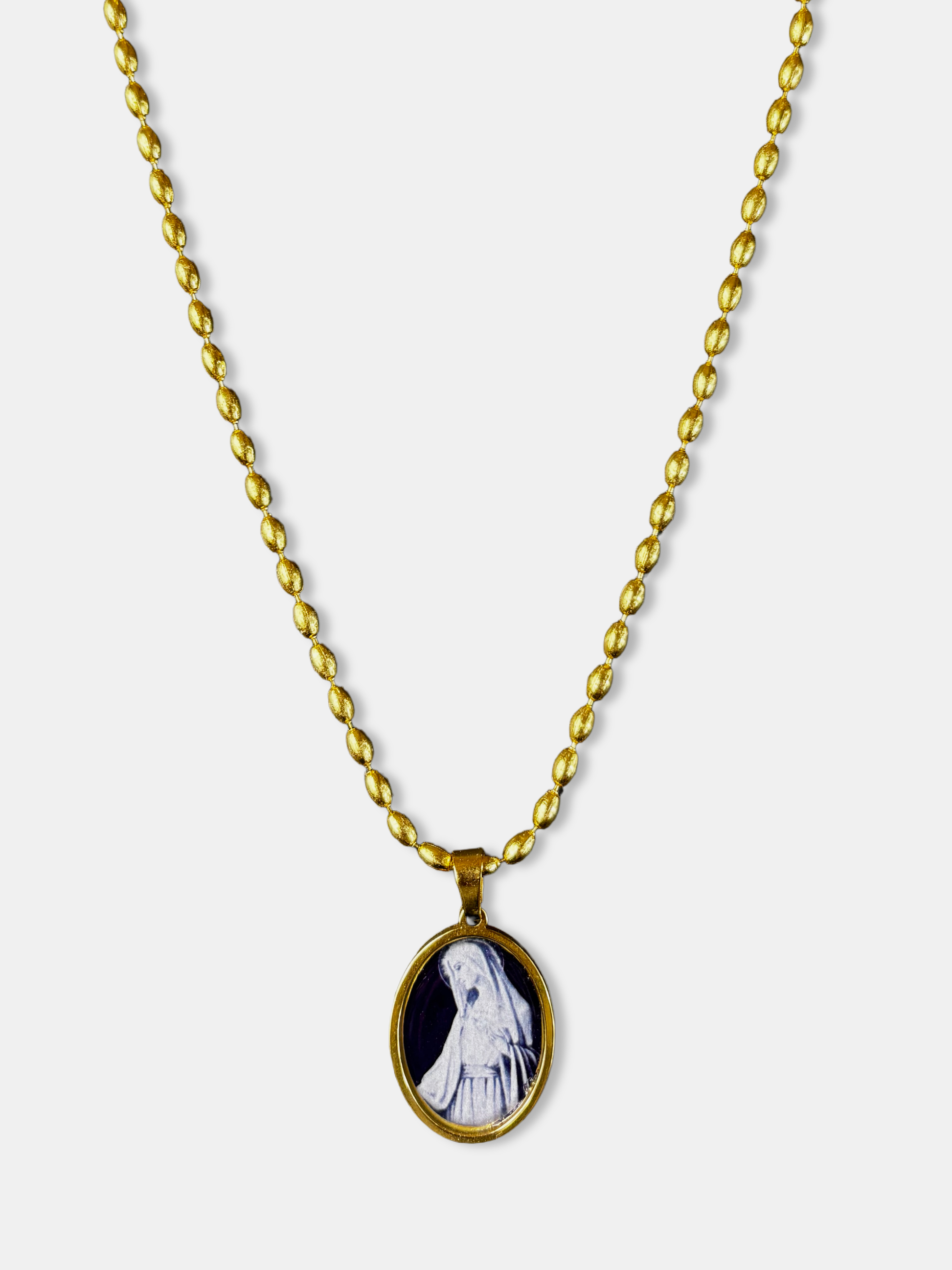 Delicate gold-filled necklace featuring an oval black pendant with white Virgin Mary illustration.