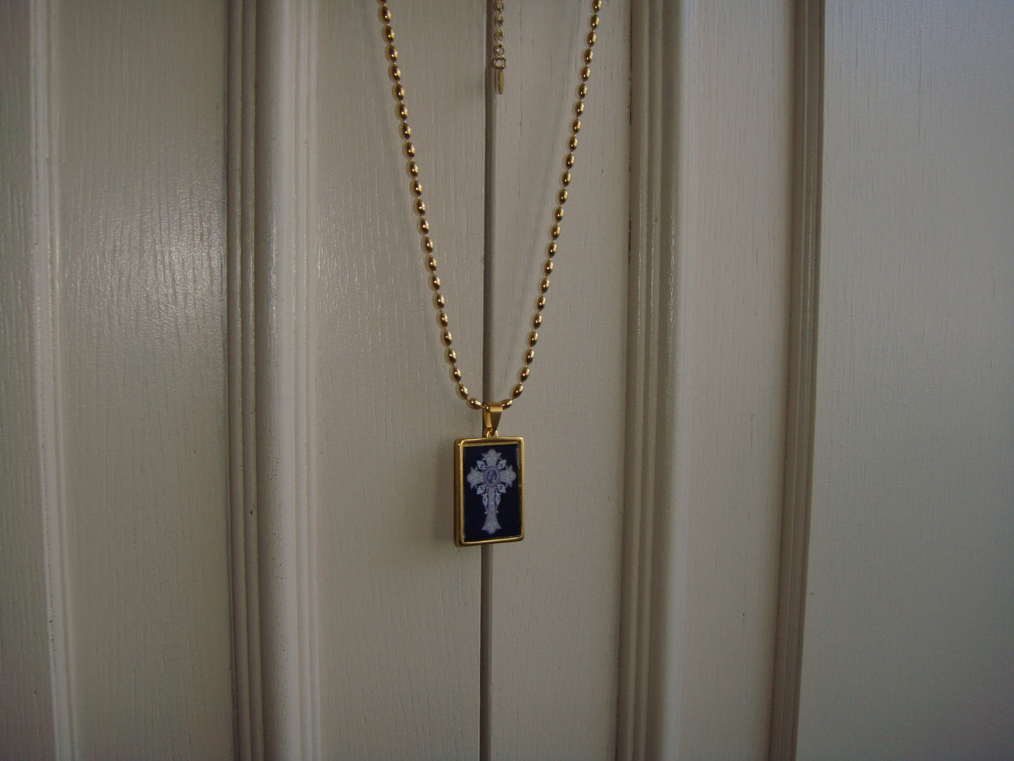 Cross pendant necklace in gold and black tones