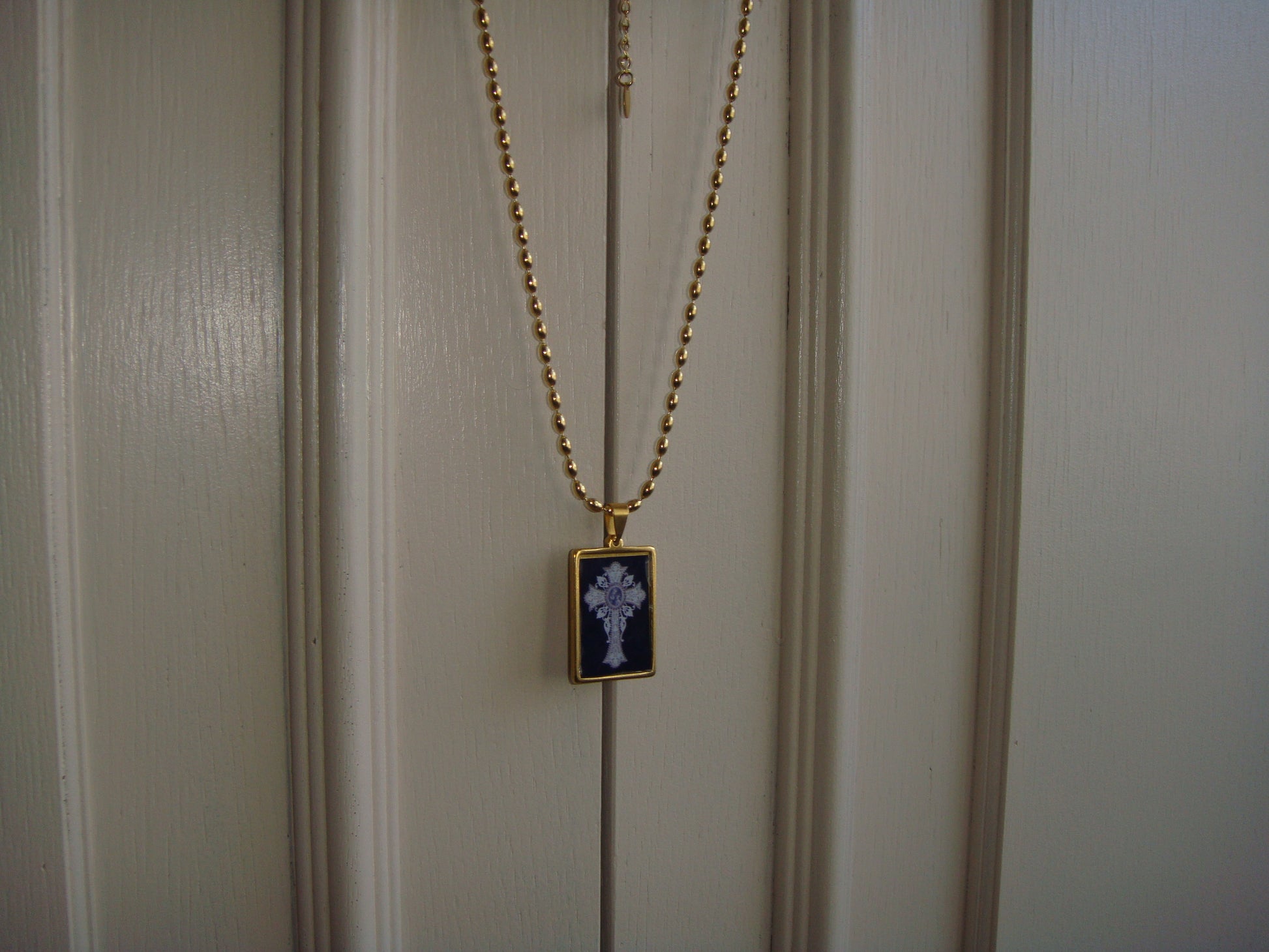 Cross pendant necklace in gold and black tones