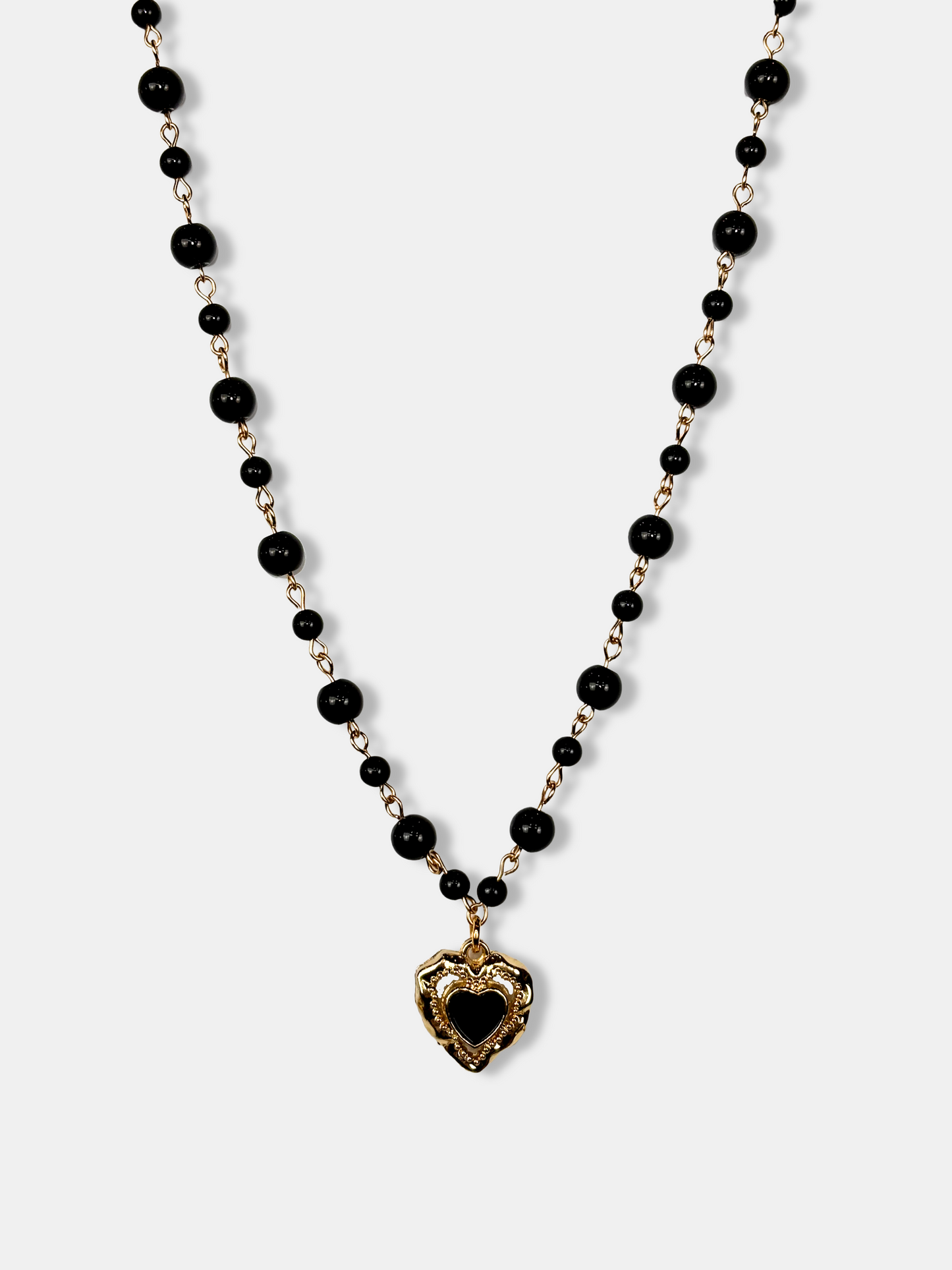 Elegant black onyx bead choker with a gold-plated heart pendant, styled for alternative and cute goth aesthetics.