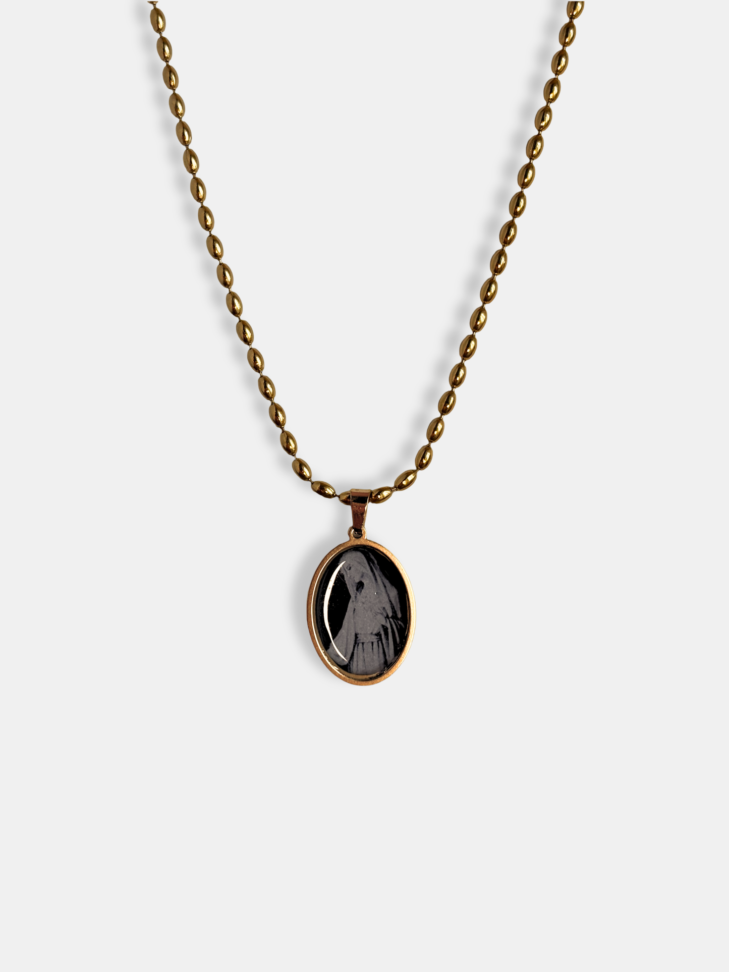 Gothic gold-filled necklace featuring a tiny glass-like cabochon of the Virgin Mary.