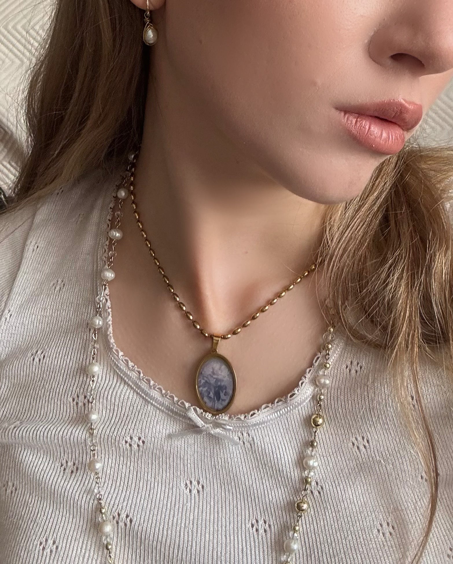 Delicate gold necklace showcasing a vintage-style oval pendant with a rose motif.