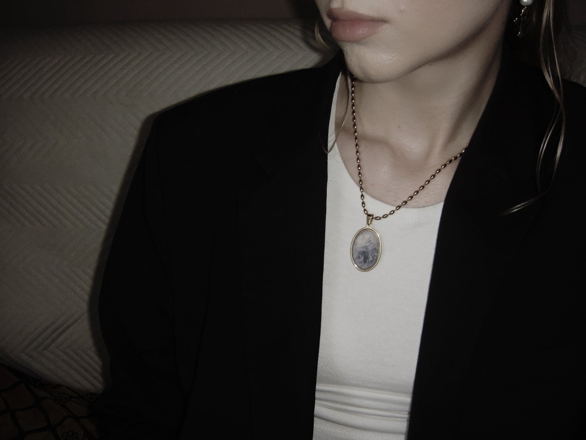 Dark romantic gold necklace with oval pendant, featuring a faded rose artwork on white background.