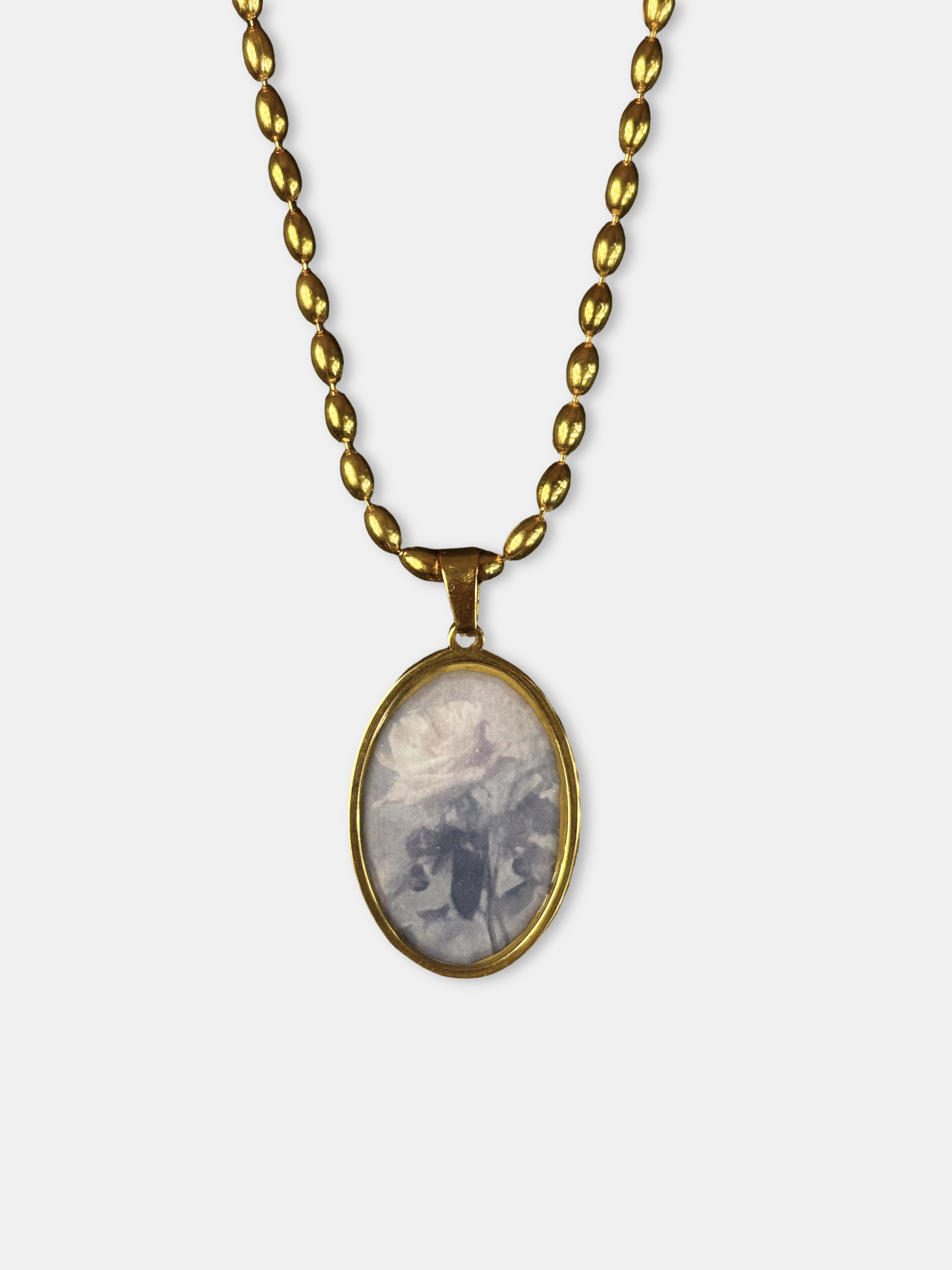 Gold medallion showcasing a vintage-style oval pendant with a rose motif.