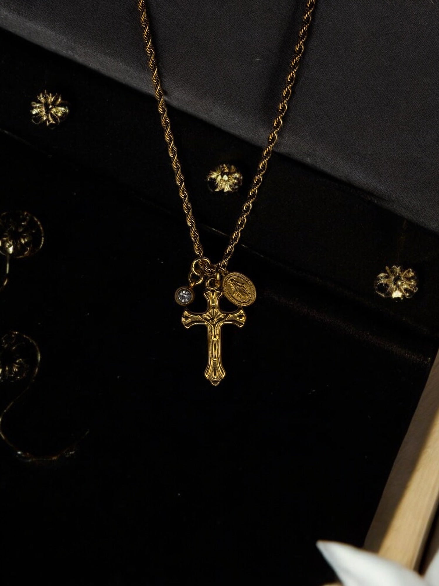 Trendy gold cross necklace with a religious crucifix pendant, Miraculous Medal charm, and a minimalist gemstone accent, perfect for layering or wearing as a statement piece.