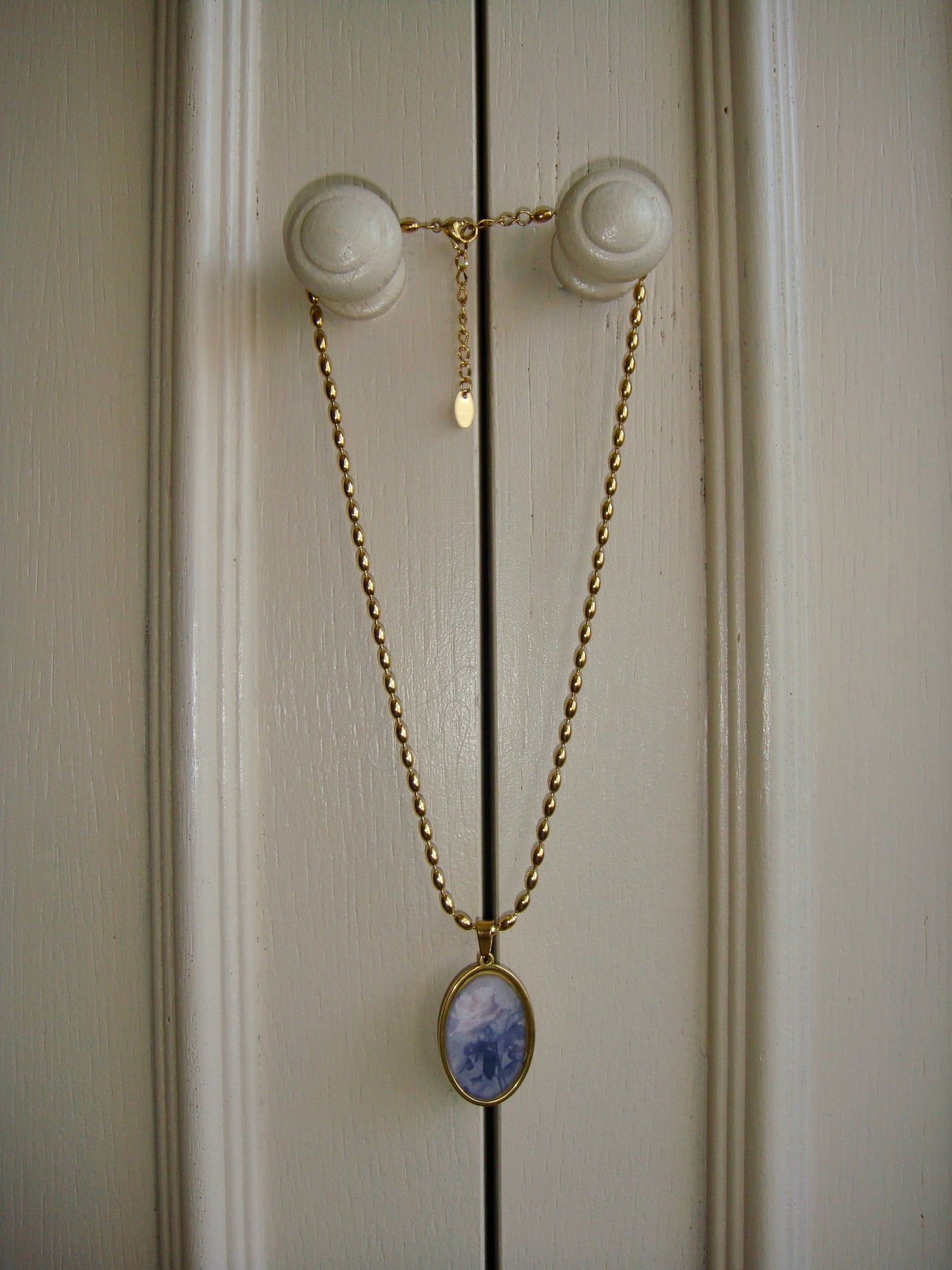 Classic oval rose pendant necklace in gold, exuding vintage elegance and artistry.